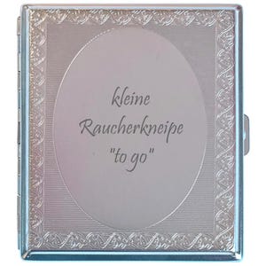 Könnte beinhalten: Ein rechteckiges Zigarettenetui aus silberfarbenem Metall mit einem verzierten, geprägten Randmuster und einem ovalen Mittelfeld. In der Mitte ist der Text "kleine Raucherkneipe "to go"" in einer dunklen Schreibschrift eingraviert.