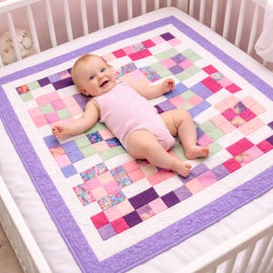 May include: A square patchwork quilt featuring a grid of small fabric squares in shades of pink, purple, green, and floral patterns, bordered by a solid lavender fabric with a swirling quilted texture, resting on a white surface.