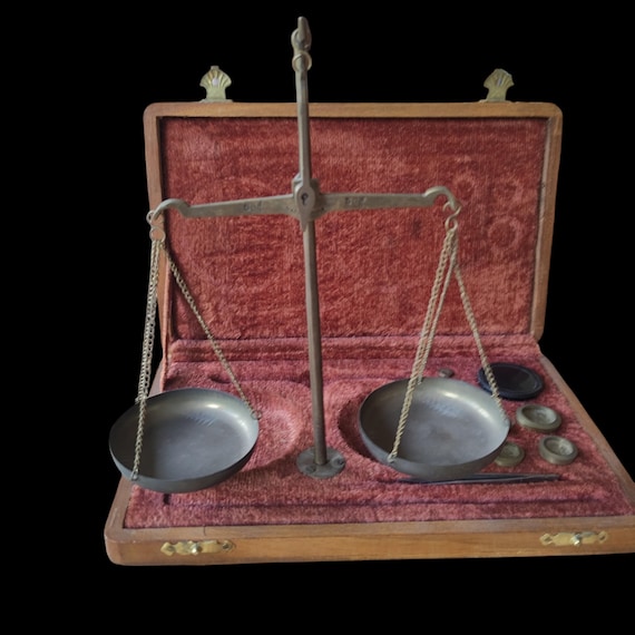 A complete antique Indian brass goldsmith's balance scale with original velvet box and weights — an actual piece of trade history that doubles as jaw-dropping desk decor.