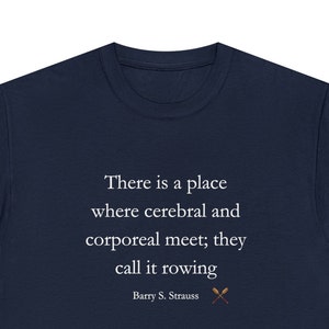 Puede incluir: Camiseta azul marino con la cita "There is a place where cerebral and corporeal meet; they call it rowing" de Barry S. Strauss. Presenta un gráfico de remos cruzados. Una camiseta cómoda e informal.