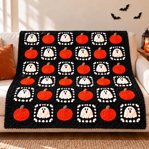 Op de afbeelding: Een rechthoekige gehaakte deken met een herhalend patroon van oranje pompoenen en witte spoken op een zwarte achtergrond. Het ontwerp bestaat uit individuele vierkante motieven met een textuurrand, met een feestelijk Halloween-thema.