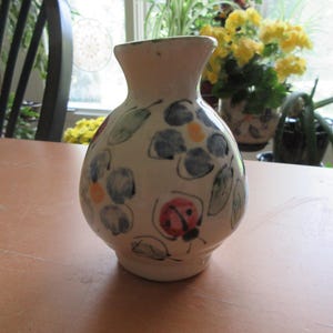 Jarrón pequeño de cerámica con diseño floral.