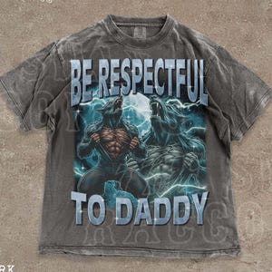 May include: Dark grey t-shirt featuring a werewolf graphic and the text "BE RESPECTFUL TO DADDY". The shirt has a vintage, distressed appearance. The words "THE SILLY RACCOON CO" are printed at the top.