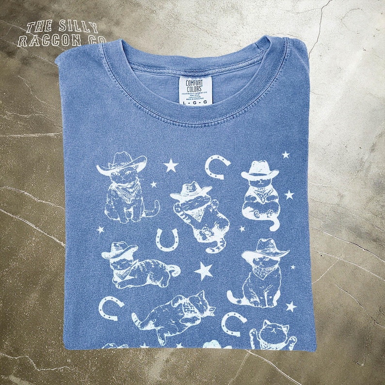 a blue t - shirt with a picture of a cowboy on it