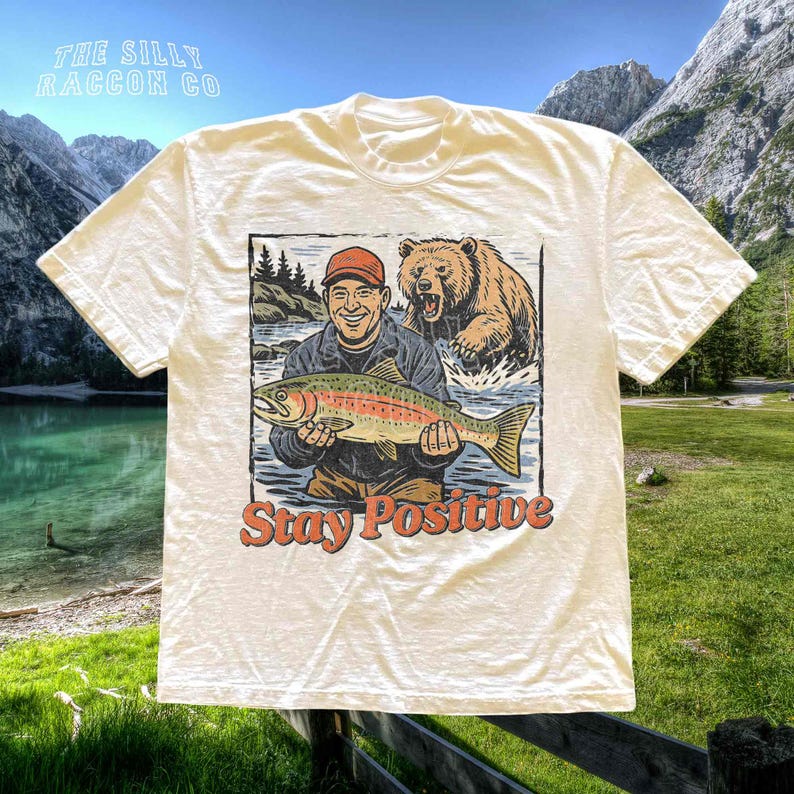 a t - shirt with a picture of a man holding a fish