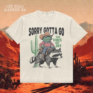 a white t - shirt with a picture of a man riding a racoon