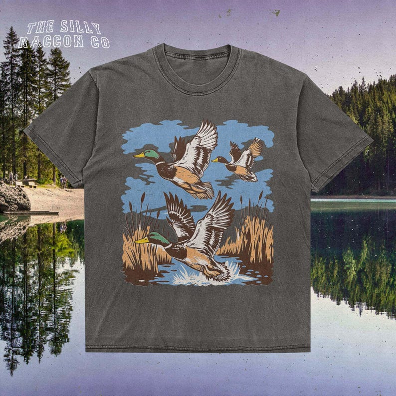 a t - shirt with ducks flying over a lake