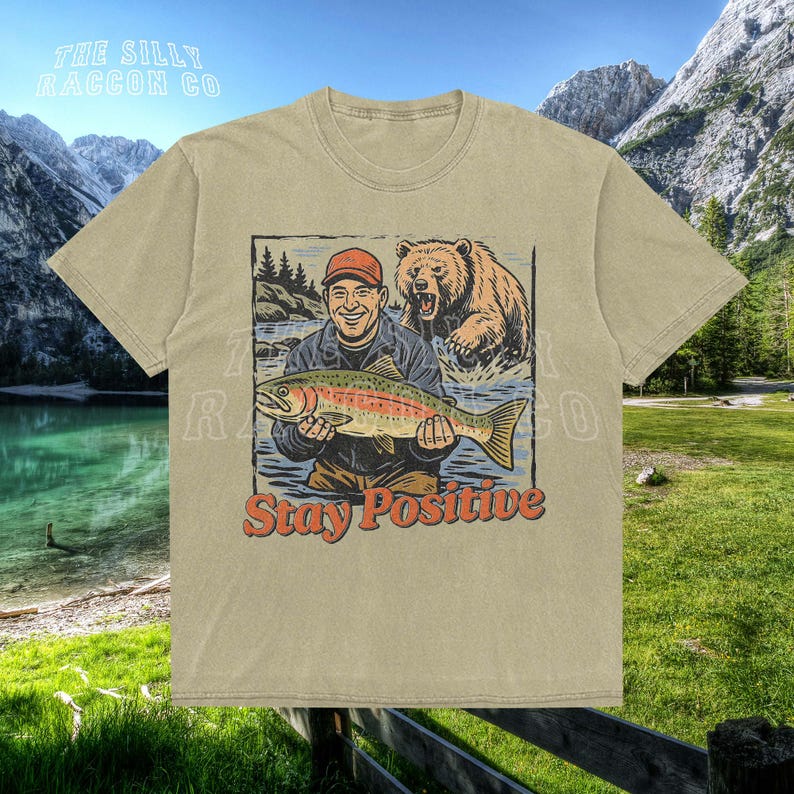 a t - shirt with a picture of a man holding a fish