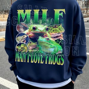 A navy blue sweatshirt with a graphic design featuring multiple green frogs.