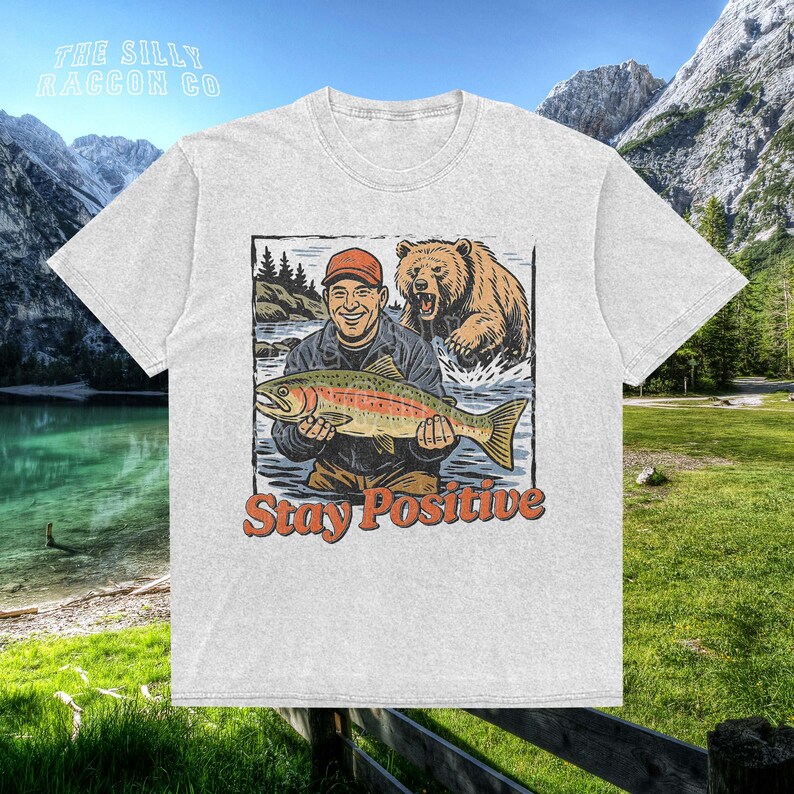a t - shirt with a picture of a man holding a fish