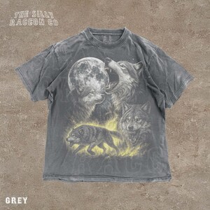 A grey t-shirt with a graphic design depicting three wolves, one of which is howling at the moon.