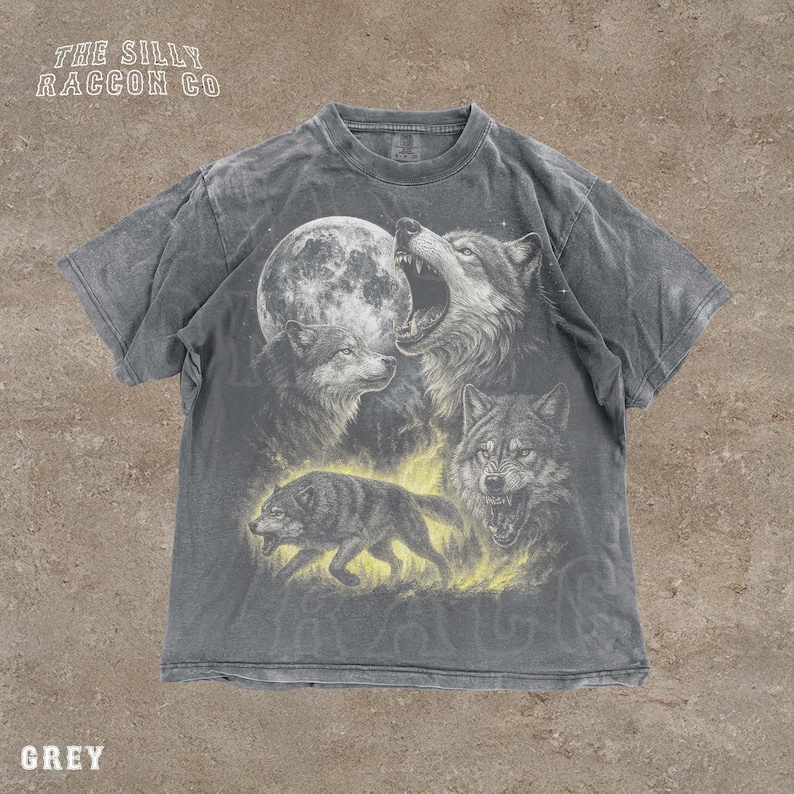 A grey t-shirt with a graphic design depicting three wolves, one of which is howling at the moon.