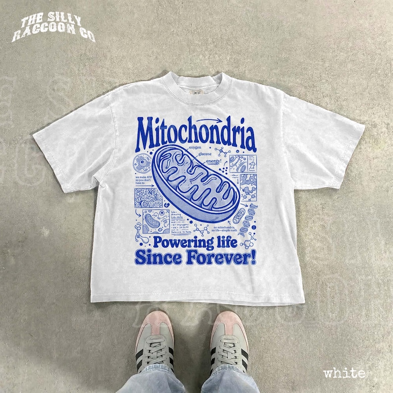 A white t-shirt with a graphic design featuring a Mitochondria-like structure and text, along with a pair of white sneakers.
