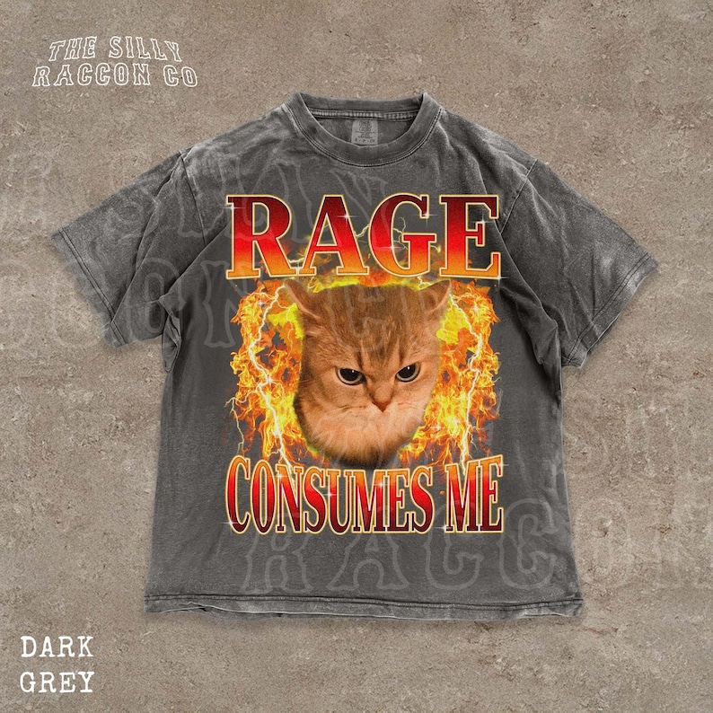 A t-shirt with a graphic design featuring a cat's face surrounded by flames, with the text "RAGE CONSUMES ME" prominently displayed.