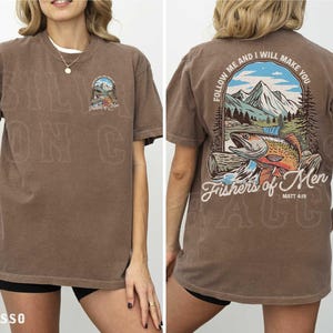 a woman wearing a brown t-shirt with a graphic design on the back. The design includes a mountain landscape with a fish, and the text "Follow Me and I will make you" along with "Fishers of Men" and "Matt. 4:9".
