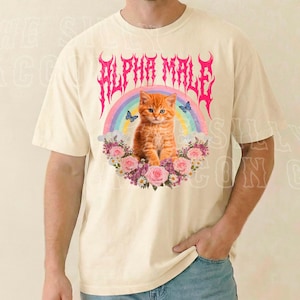 A man wearing a white t-shirt with a graphic design featuring a cat surrounded by flowers and a rainbow.