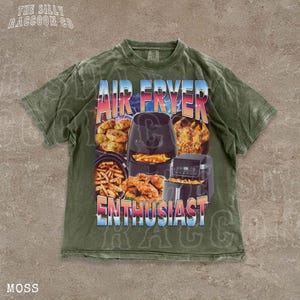 The image is a t-shirt design featuring an air fryer and various fried food items, such as chicken and french fries, along with the text "AIR FRYER ENTHUSIAST" and "MOSS" printed on it.