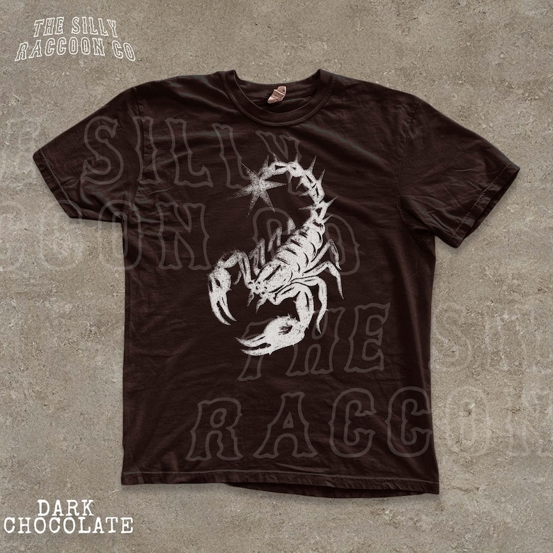A dark brown t-shirt with a white graphic design depicting a stylized scorpion.