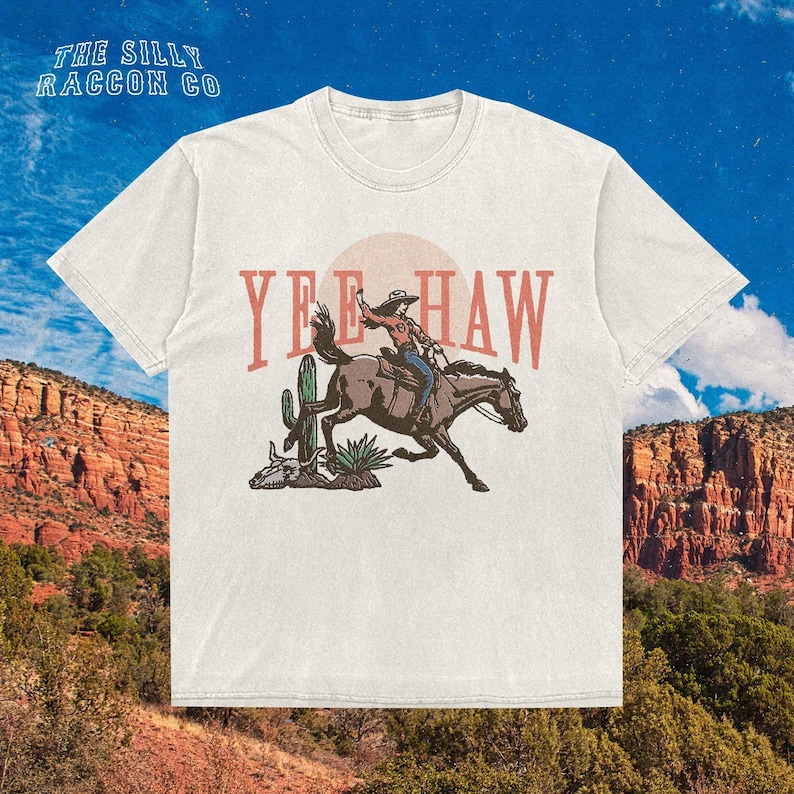 a white t - shirt with a cowboy riding a horse