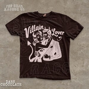 A black t-shirt with a graphic design featuring a man and a woman embracing, with the text " Villain Lover" and "RAC" printed on it.