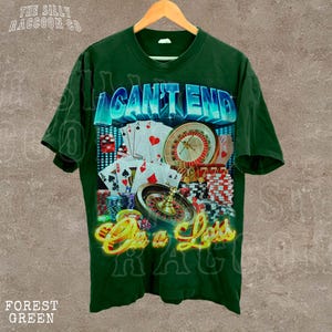 A green t-shirt with a graphic design featuring casino elements such as a roulette wheel, playing cards, and poker chips.