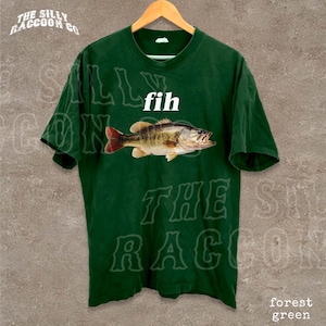 A green t-shirt with a printed image of a fish and the word "fih" printed on it.