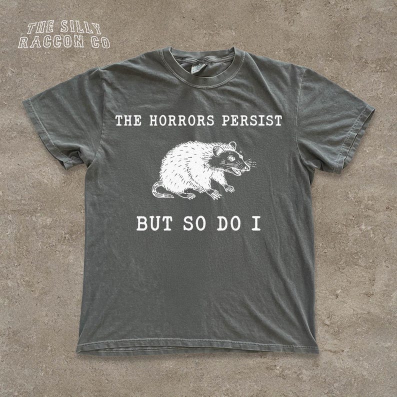 A gray t-shirt with a graphic design and text printed on it.