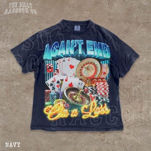 A navy blue t-shirt with a graphic design featuring various casino-related elements, including playing cards, a roulette wheel, and stacks of poker chips. The text on the t-shirt reads "I CAN'T END ON A LESS THAN 500 CHARACTERS".