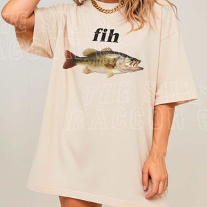 A woman wearing a white t-shirt with a graphic of a fish printed on it.