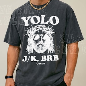 A man wearing a black t-shirt with a graphic design featuring a stylized depiction of Jesus and the text "YOLO J/K, BRB - Jesus".