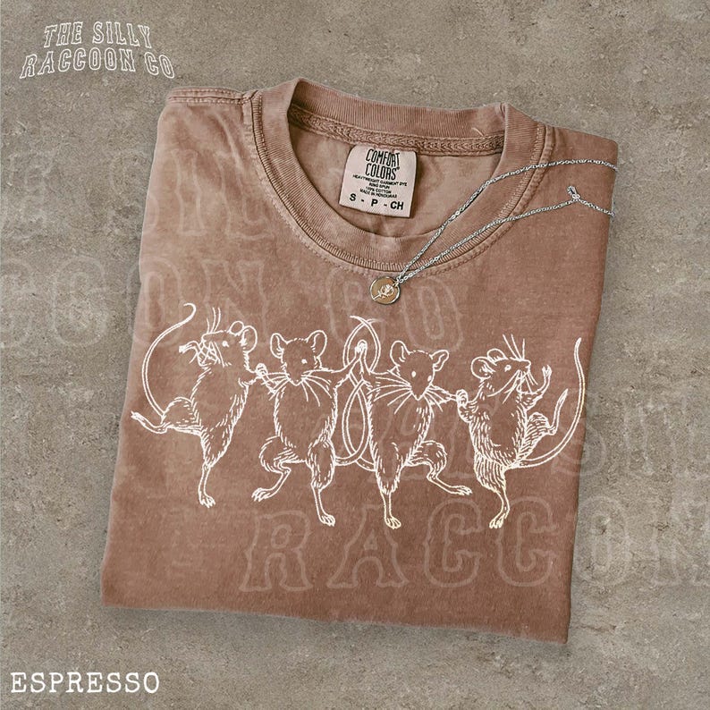 A brown t-shirt with a design of four cartoon mice dancing, accompanied by the text "ESPRESSO" printed on it.