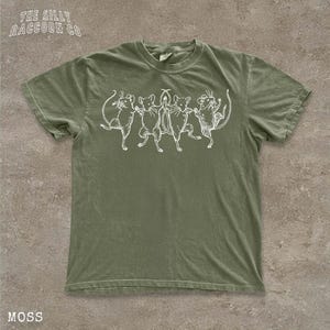 A green t-shirt with a white graphic design depicting a group of cats or mice.