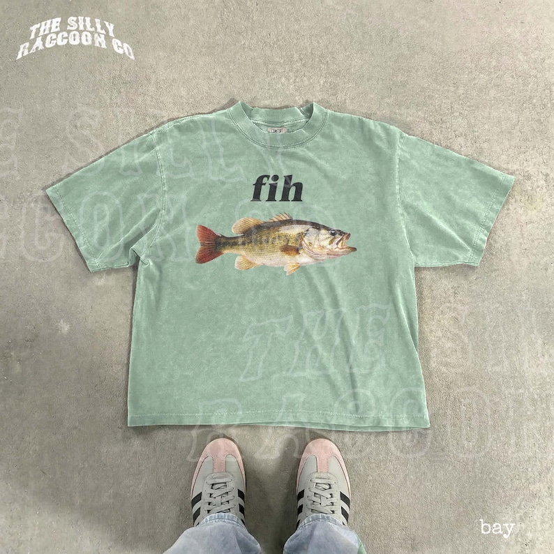 A green t-shirt with a fish graphic and the word 'fih' printed on it, along with a pair of white sneakers.