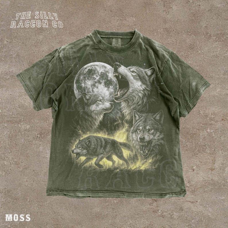 A t-shirt with a graphic design depicting three wolves, one of which is howling at the moon.