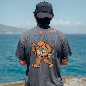 a man standing on top of a cliff next to the ocean