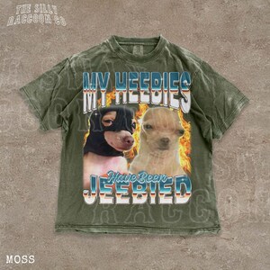 A t-shirt with a graphic design featuring two dogs, one black and one tan, with flames and text overlaying the image.