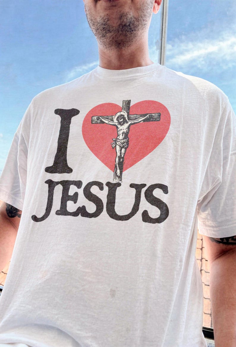 A person wearing a white t-shirt with the text "I ♥ JESUS" printed on it.