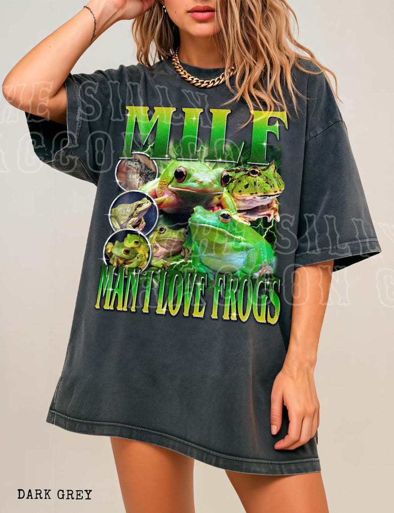 A woman wearing a black t-shirt with a graphic design of green frogs.