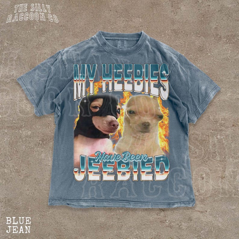 A t-shirt with a graphic design featuring two dogs, one black and one tan, with flames and text overlaying the image.
