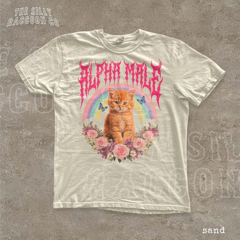 A white t-shirt with a graphic design featuring an orange cat surrounded by flowers and a rainbow.