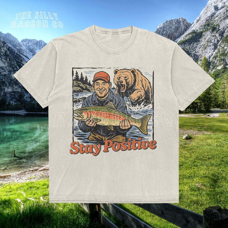 a t - shirt with a picture of a man holding a fish