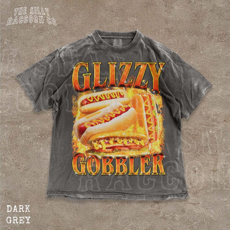 A grey t-shirt with a graphic design featuring two hot dogs on a flame background, along with the text "GLIZZY GOBBLER" prominently displayed.