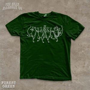 A green t-shirt with a white illustration of a group of mice dancing together.