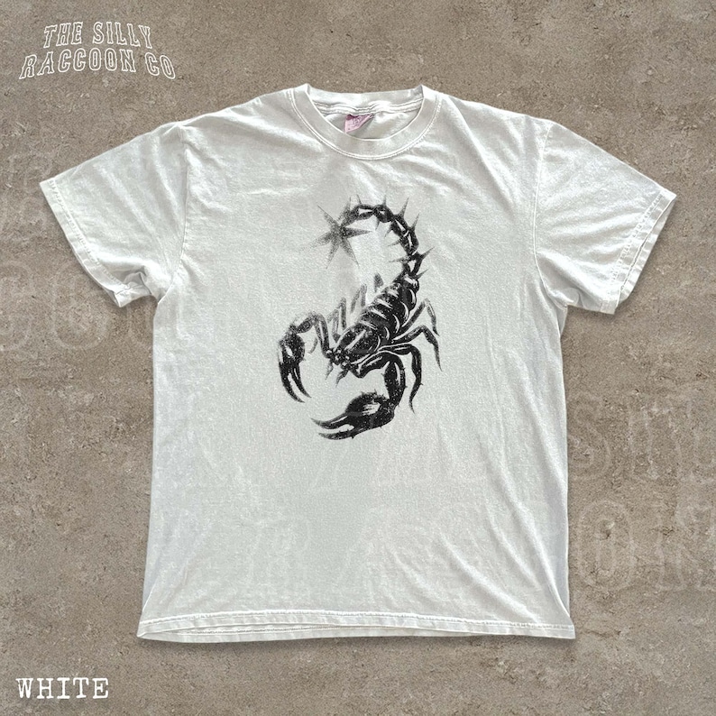 A white t-shirt with a black graphic of a scorpion printed on it.