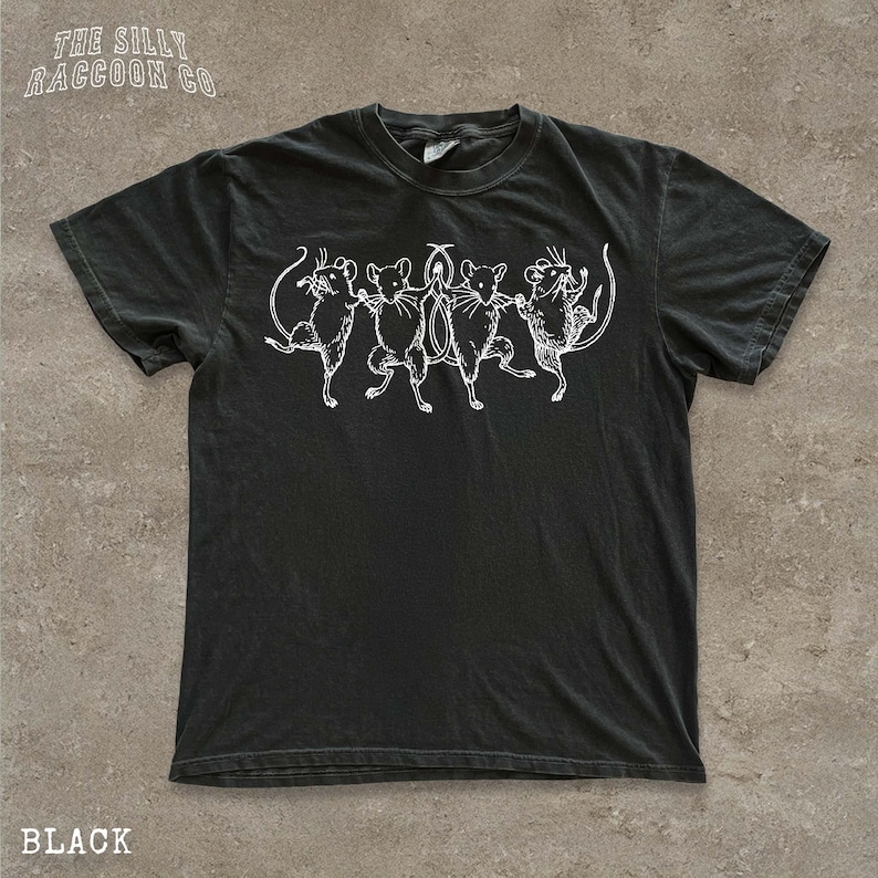 A black t-shirt with a graphic design of five cats in various poses, including one standing on its hind legs.
