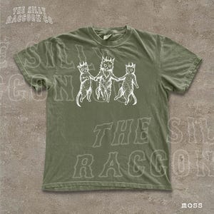 A green t-shirt with a graphic design featuring three cartoon cats holding hands.