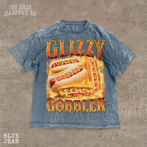 A blue t-shirt with a graphic design featuring two hot dogs on a fire background, along with the text "GLIZZY GOBBLER".
