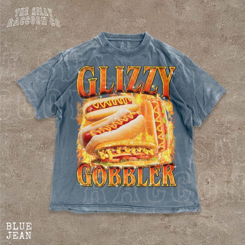 A blue t-shirt with a graphic design featuring two hot dogs on a fire background, along with the text "GLIZZY GOBBLER".