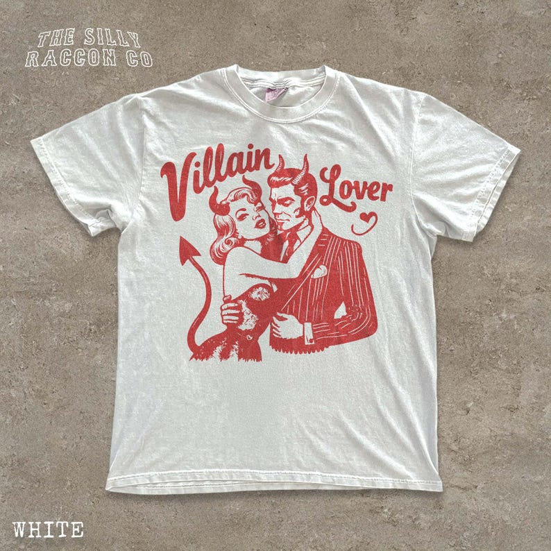 A white t-shirt with a graphic design depicting a man and a woman embracing, with the text " Villain Lover" above them.