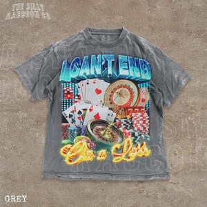 A grey t-shirt with a graphic design featuring various casino-related elements, including playing cards, a roulette wheel, and stacks of chips. The text on the t-shirt reads "I CAN'T END" and "On a Loss".